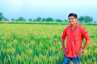 young  indian farmer at wheat field
