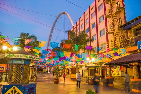 Meksika - Tijuana - Santiago Arguello üzerinde bayrak, milenyum kemeri (el arco y reloj monumental) ve bulanık hareket siluetleri ile alışveriş ve bar caddeleri yayaya çıktı
