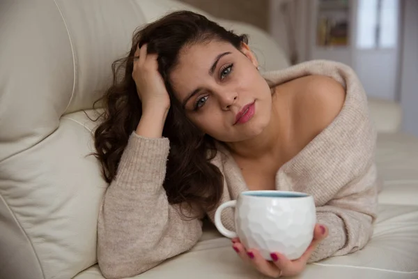 Όμορφη Κοπέλα Ξαπλωμένη Στον Καναπέ Και Πίνει Καφέ — Φωτογραφία Αρχείου