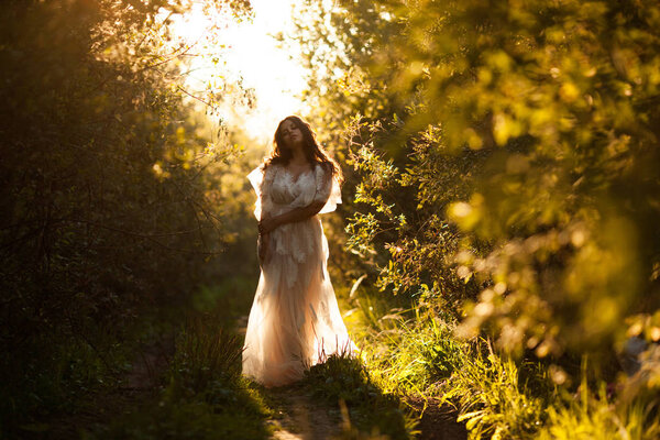 Beautiful girl in a dress at sunset