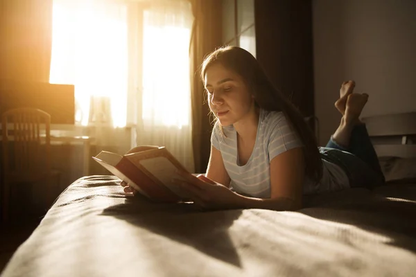 Nettes Langhaariges Mädchen Lügt Und Liest Ein Buch — Stockfoto