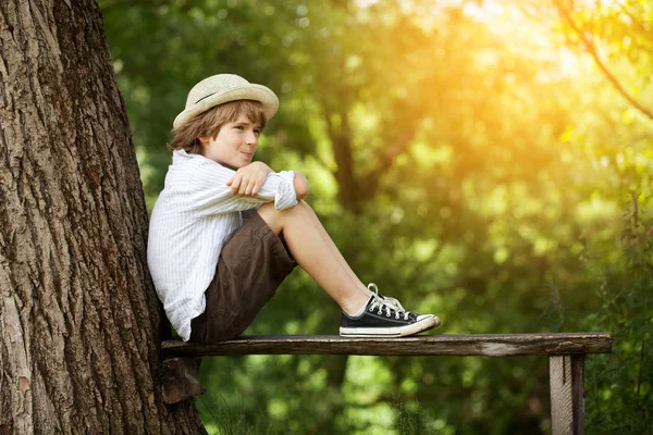 Ragazzo Pantaloncini Cappello Siede Una Panchina — Foto Stock