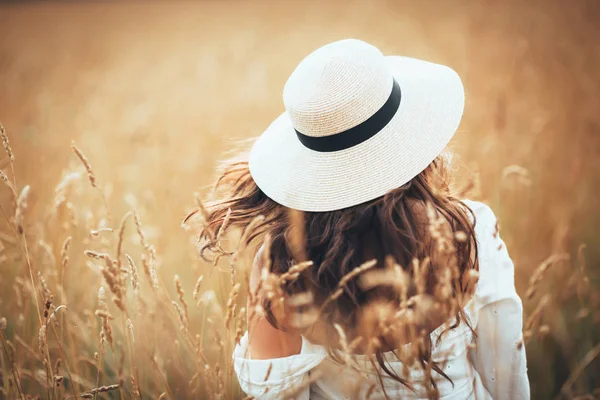 Kobieta w kapeluszu chodzenie na łące — Zdjęcie stockowe