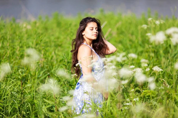 Glückliches schönes Mädchen inmitten von Wildblumen — Stockfoto