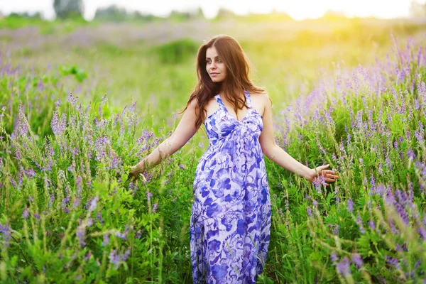 Hermosa chica de pelo oscuro entre flores silvestres — Foto de Stock