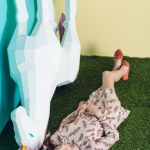 Stylish youth girl lying with big white unicorn