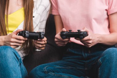 video oyun oynarken elinde joystick ile iki kadın arkadaş resim kırpılmış 