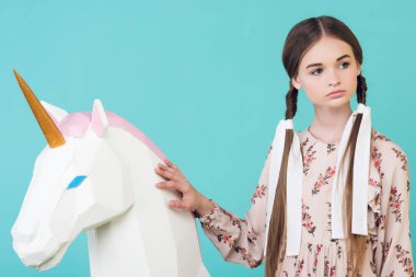 Turkuaz üzerinde izole büyük beyaz unicorn ile poz güzel genç kız