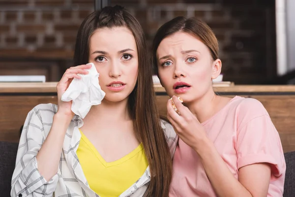 Joven Mujer Limpiando Lágrimas Por Servilleta Mientras Amiga Comiendo Palomitas — Foto de Stock