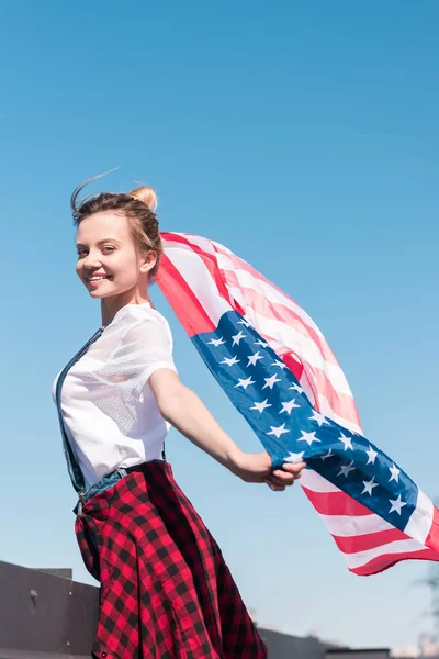 青い空 独立記念日の概念に対してアメリカの国旗を保持している若い女性 — ストック写真