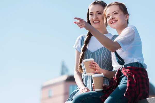 Young Woman Pointing Finger Smiling Female Friend Paper Cup Coffee — Stock Photo, Image