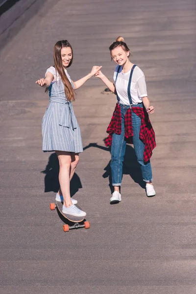 Upphöjd Syn Kvinnan Undervisning Sin Kvinnliga Vän Som Rider Skateboard — Gratis stockfoto