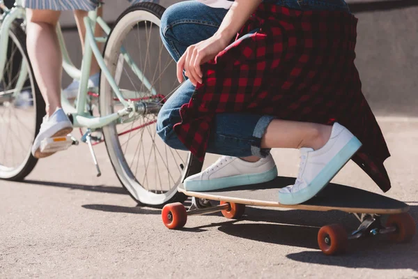 Cropped Shot Woman Riding Bicycle Towing Her Female Friend Skateboard — Stock Photo, Image