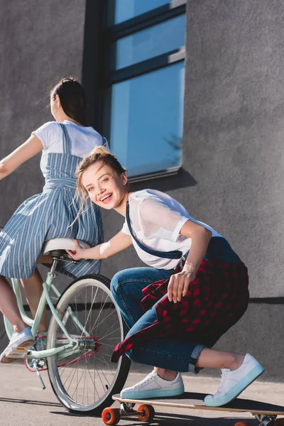 Donna Bicicletta Rimorchiare Suo Amico Femminile Sorridente Skateboard — Foto Stock