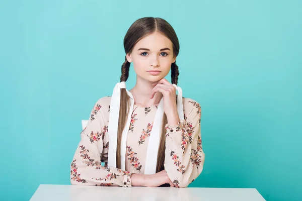 Adolescente Chica Con Trenzas Sentado Mesa Aislado Azul — Foto de stock gratis