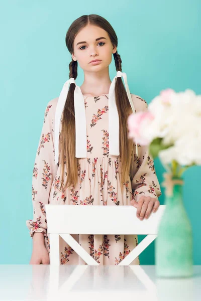 Adolescente Chica Con Trenzas Posando Cerca Mesa Con Flores Aislado — Foto de Stock