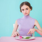 Beautiful teen girl on diet eating tulip flower