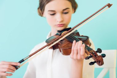beautiful girl playing violin, isolated on blue clipart