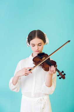 attractive teen girl playing violin, isolated on turquoise clipart
