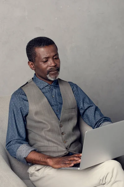 认真成熟的非洲裔美国商人使用笔记本电脑在工作 — 免费的图库照片