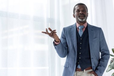 mavi ceket ve pencere işaret içinde düşünceli Afrikalı-Amerikalı iş adamı