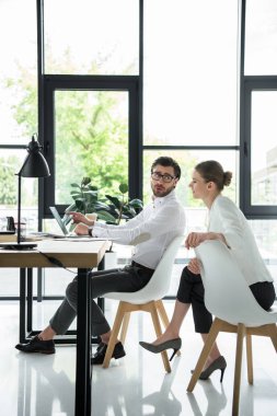 side view of young attractive managers working together at modern office clipart