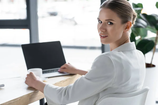成功的年轻女商人在现代办公室使用笔记本电脑 — 图库照片