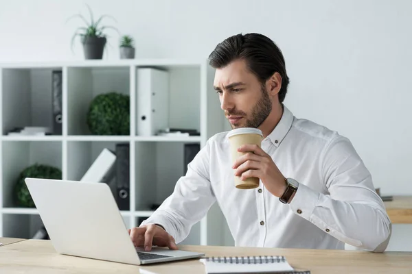 Schöner Junger Geschäftsmann Mit Pappbecher Kaffee Der Mit Laptop Arbeitet — Stockfoto
