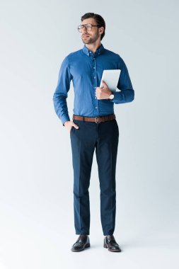 Beyaz tablete ile şık giysiler içinde çekici genç adam