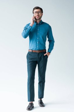 telefonla konuşurken beyaz şık giysiler içinde yakışıklı genç