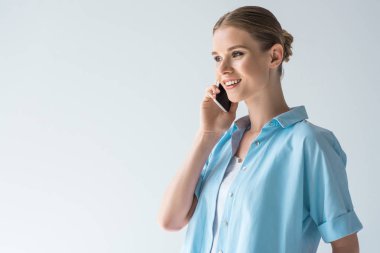mutlu genç kadın üzerinde beyaz izole telefonla konuşmak mavi gömlekli