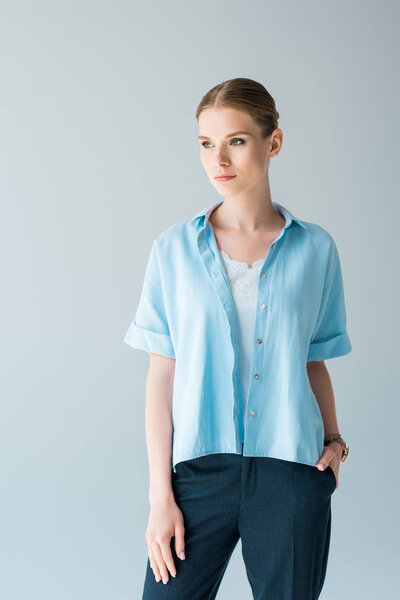 beautiful young woman in stylish blue shirt isolated on grey