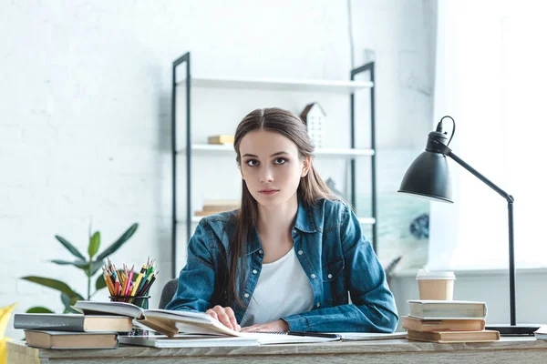 Atractiva Chica Adolescente Sentada Escritorio Mirando Cámara Mientras Estudia Casa — Foto de Stock