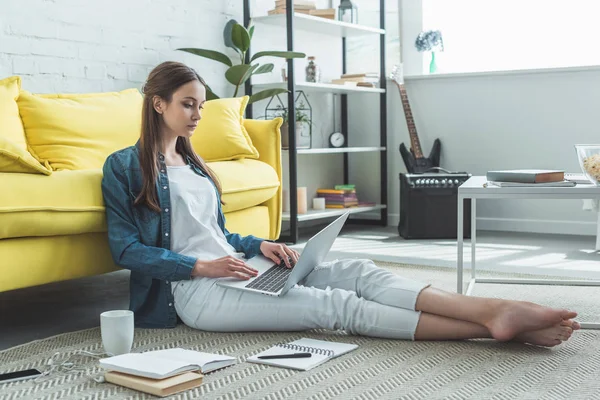 Konzentriertes Barfußmädchen Mit Laptop Auf Teppich Sitzend Und Hause Studierend — Stockfoto