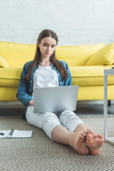 Schönes Fokussiertes Barfußmädchen Mit Laptop Während Hause Auf Teppich Sitzt — Stockfoto