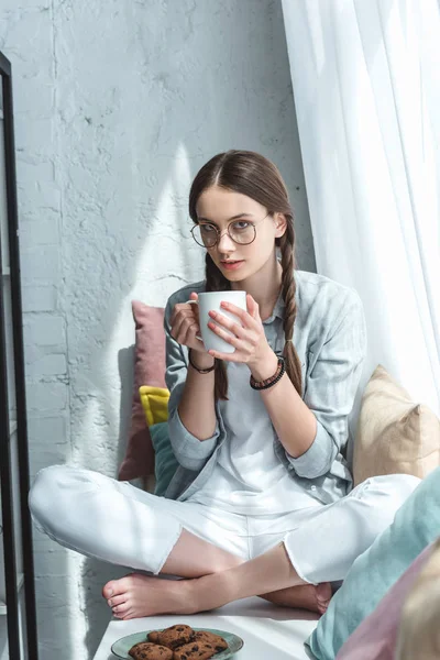 Aantrekkelijke Tiener Meisje Eten Koekjes Met Koffie Vensterbank Met Kussens — Stockfoto