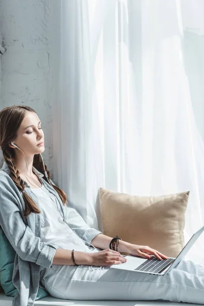 Atractiva Chica Adolescente Usando Portátil Escuchar Música Con Auriculares Alféizar —  Fotos de Stock