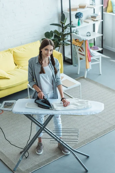 Jeune Fille Avec Tresses Repassage Pantalon Blanc Dans Salon — Photo gratuite