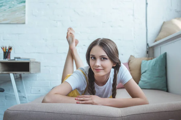 Schöne Lächelnde Teenie Mädchen Mit Zöpfen Auf Dem Sofa Liegend — Stockfoto