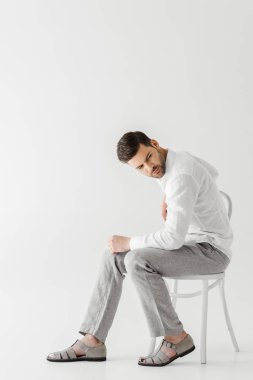 keten giysiler dış saha üzerinde izole gri arka plan seyir sandalyede oturan adam 