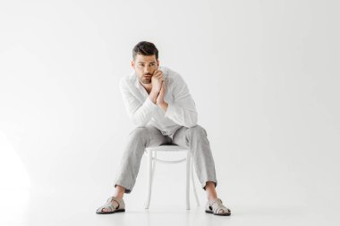 keten elbise gri arka plan üzerinde izole sandalyede otururken yakışıklı adam 