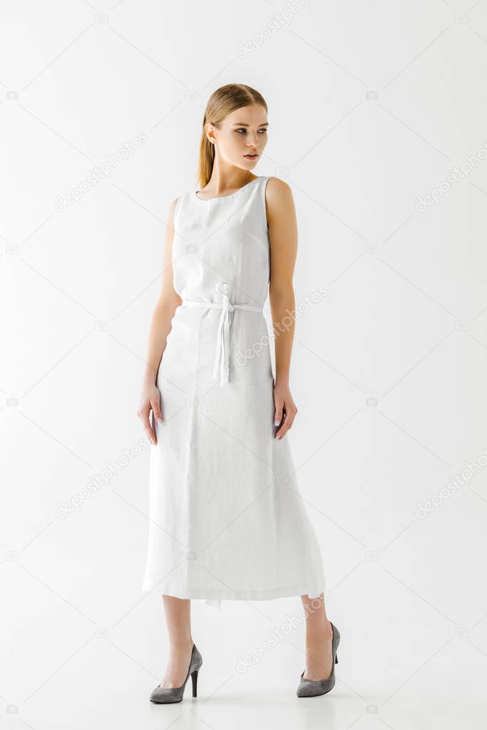 attractive woman in linen white dress looking away isolated on grey background 