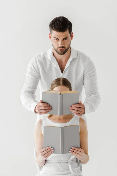 Handsome Man Covering Face Girlfriend Sitting Chair Reading Book Isolated — Stock Photo, Image