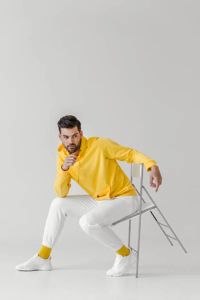 Attrayant Jeune Homme Capuche Jaune Assis Sur Chaise Sur Blanc — Photo