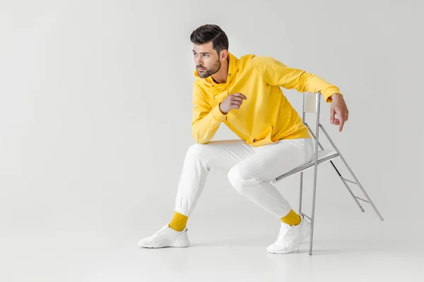 Jovem Elegante Com Capuz Amarelo Sentado Cadeira Branco — Fotografia de Stock