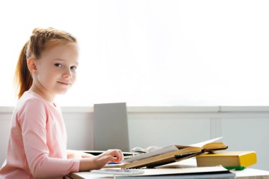 evde okurken kameraya gülümseyen güzel kız öğrenci