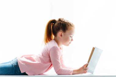 güzel küçük kız öğrenci kenarında yalan ve kitap okuma 