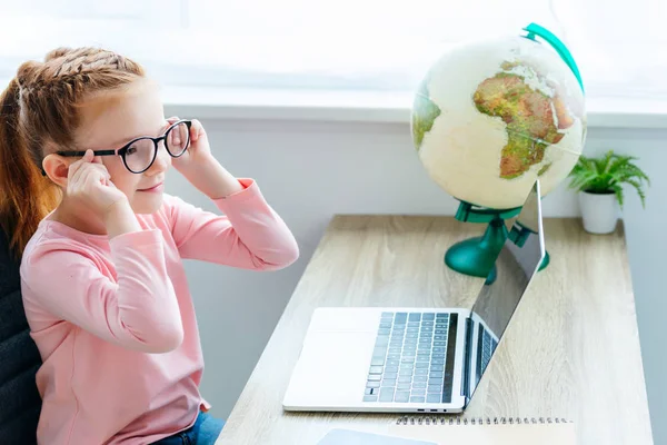 Aranyos Mosolygós Gyermek Használ Laptop Miközben Íróasztal — ingyenes stock fotók