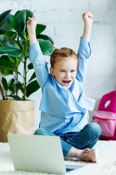 Cheerful Little Schoolgirl Raising Hands While Studying Laptop Home — Free Stock Photo