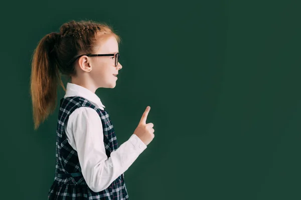 Oldalnézetből Kis Mosolygó Iskoláslány Mutató Ujjával Állva Közelében Tábla Szemüvegek — Stock Fotó